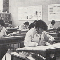 Black and white image of students sitting at desks in a classroom