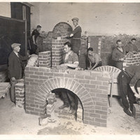 Black and white image of men practicing bricklaying 