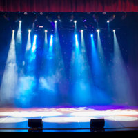 A bare stage with spotlights coming down
