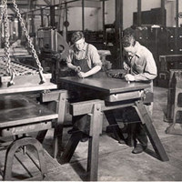 Two people working on wooden table in 1940 