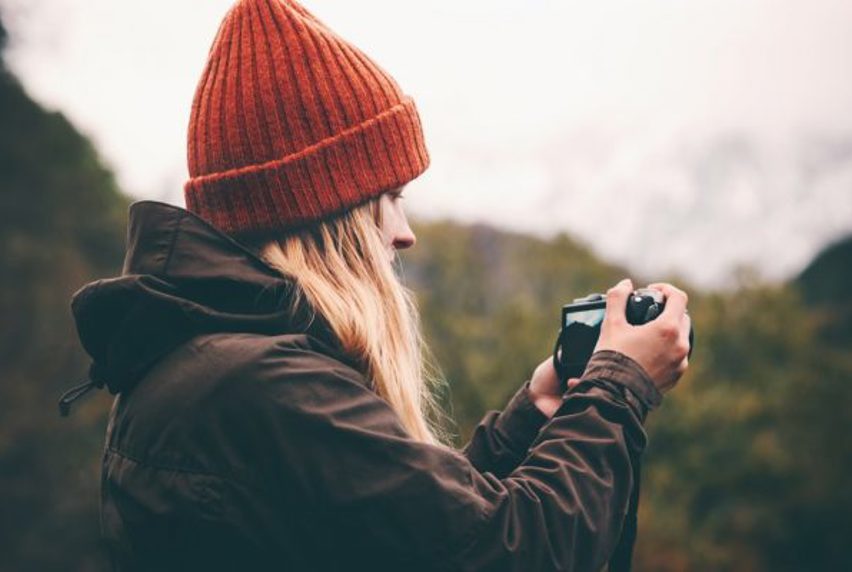 Woman in beanie holding a camera