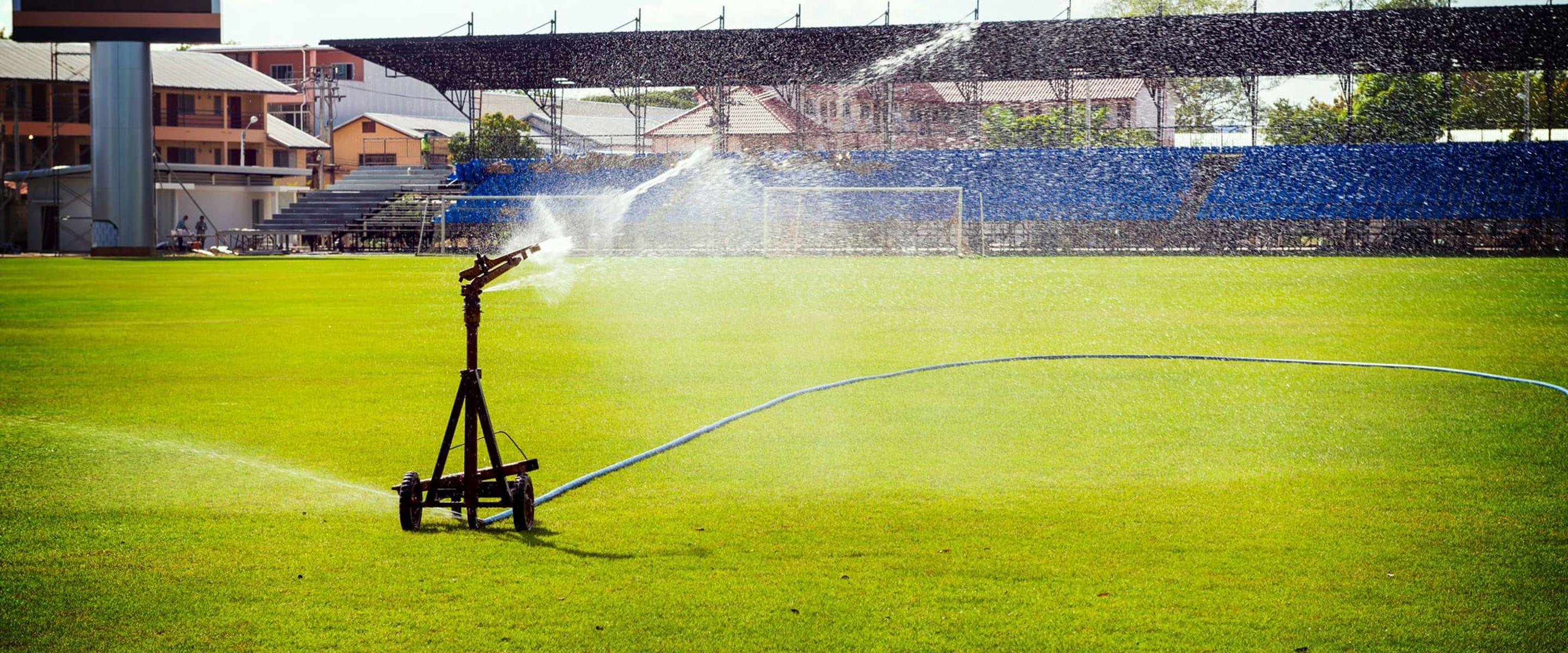 A water sprinkler watering a sporting field