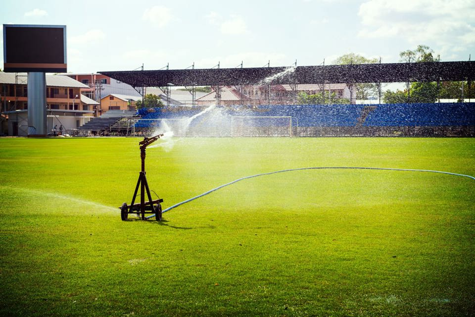 A water sprinkler watering a sporting field