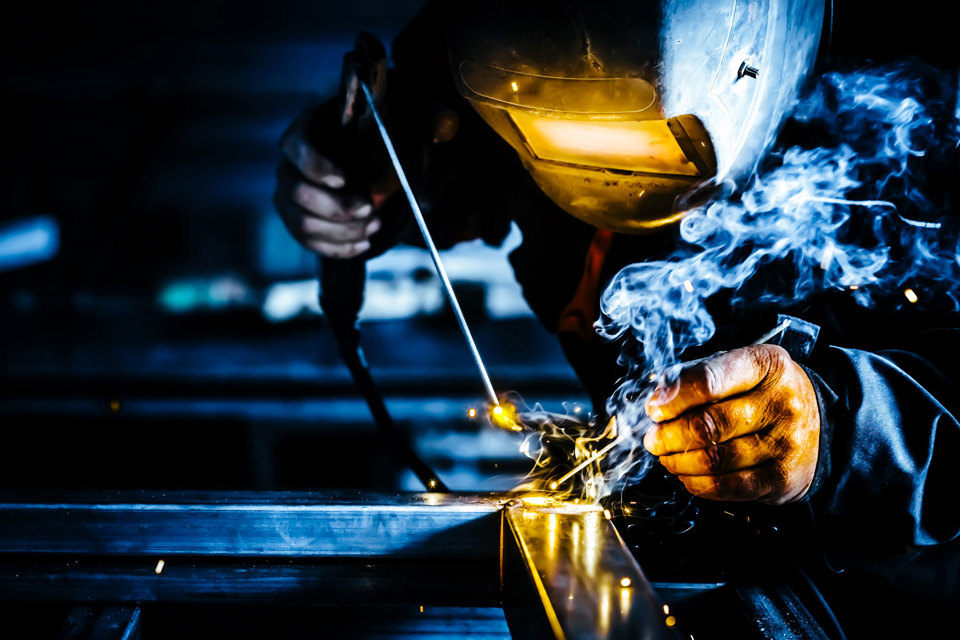 A close-up of a man welding a metal frame