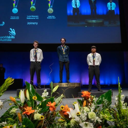 Melbourne Polytechnic student, Luca Mascaro, standing on the podium after winning the gold medal for Joinery at the WorldSkills Australia National Championships