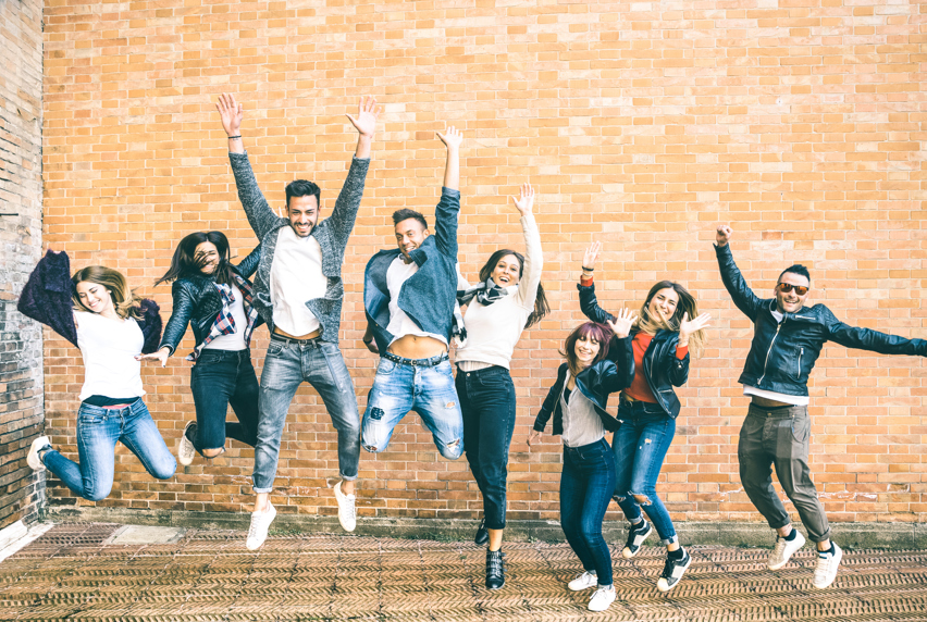 Image of smiling students jumping in the air 