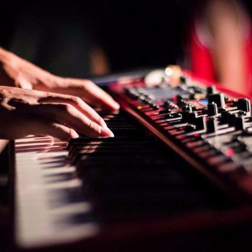 Hands playing a synthesiser 