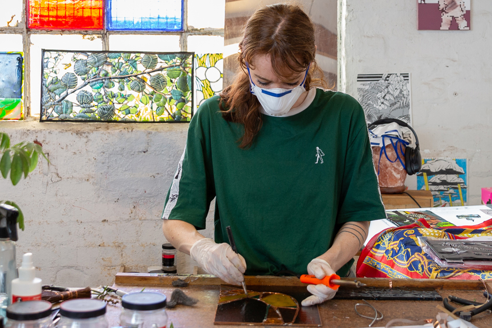 Woman in workshop decorating coloured glass