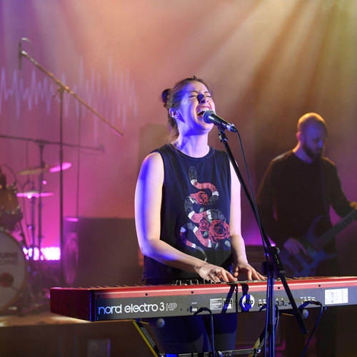 Musician playing a synthesiser and singing with a band