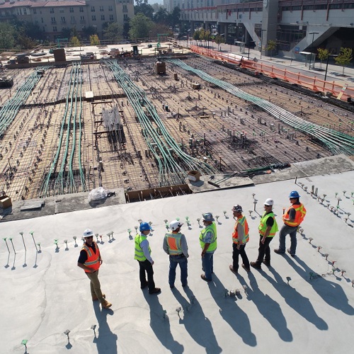 Workers standing next to a large construction site