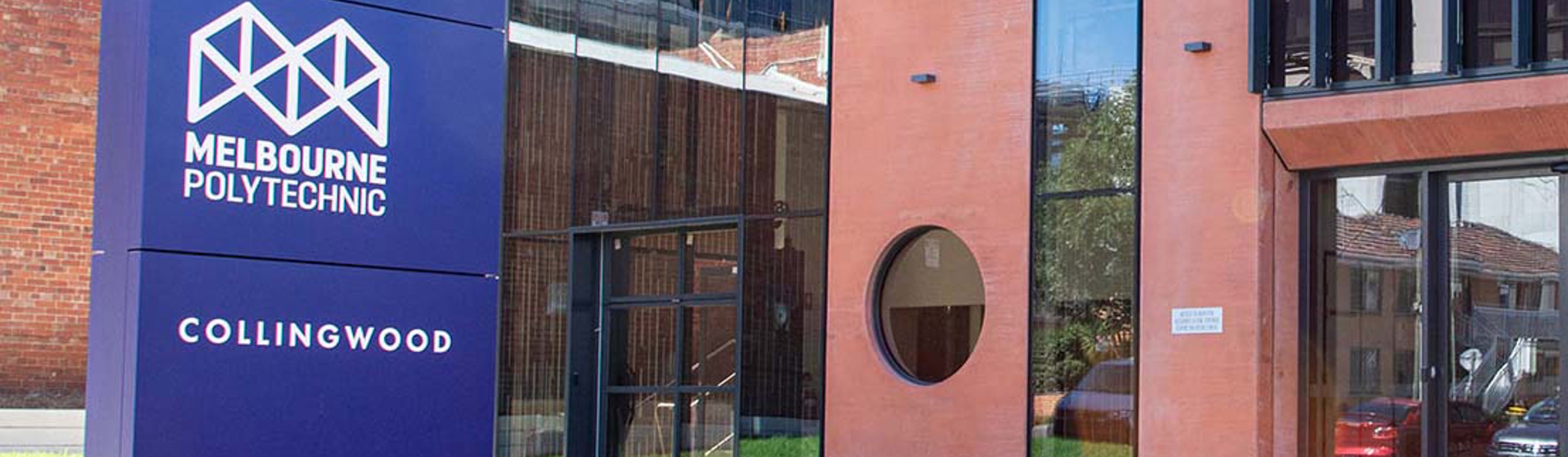 The Collingwood Campus entrance, displaying a blue sign that states "Melbourne Polytechnic."