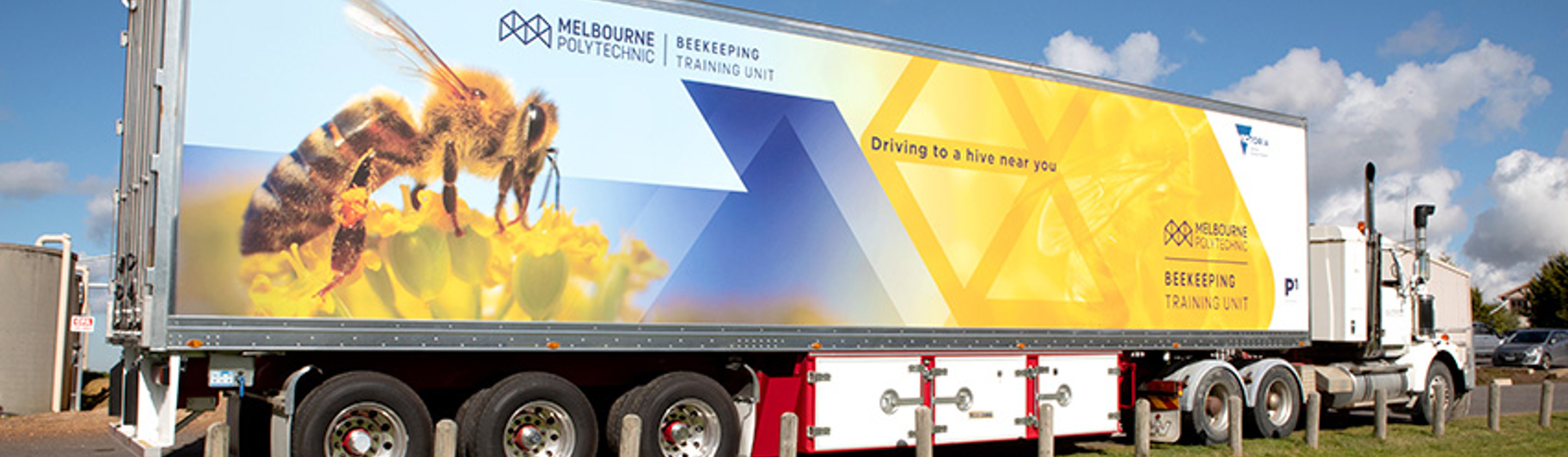 A large truck with "Melbourne Polytechnic Beekeeping Training Unit" and an image of a bee printed on the side.