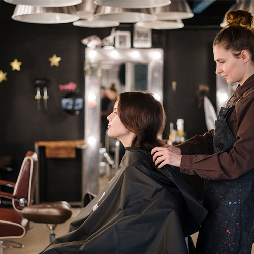 Young hairdressing student working on a customer in a hair salon