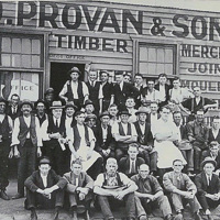 Old Black and White photo of D.Proven and Sons, with employees in a posing in a group out the front of the building