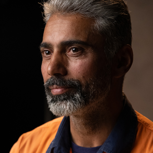 Kulwant Singh wearing high visibility work clothes in front of neutral coloured background.