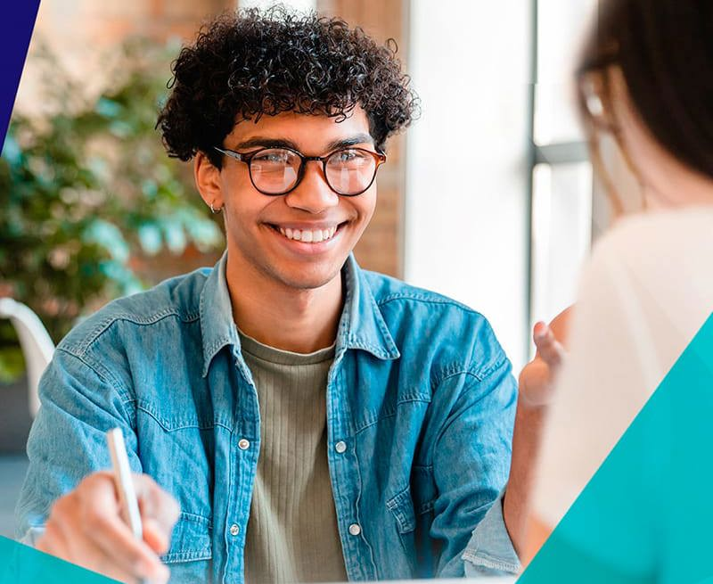 Smiling young student speaking with a career counsellor at a desk